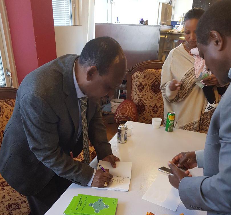 ደራሲ ሰለሞን ሐለፎም መጽሐፉን ሲፈርም